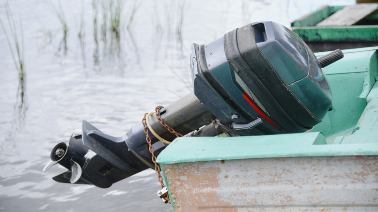 An outboard motor on an old wooden rowboat