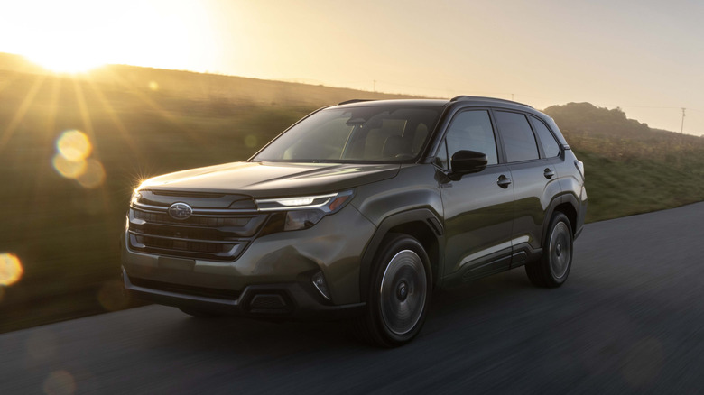A front left 3/4 of a gold 2026 Subaru Forester Hybrid on a roadway.