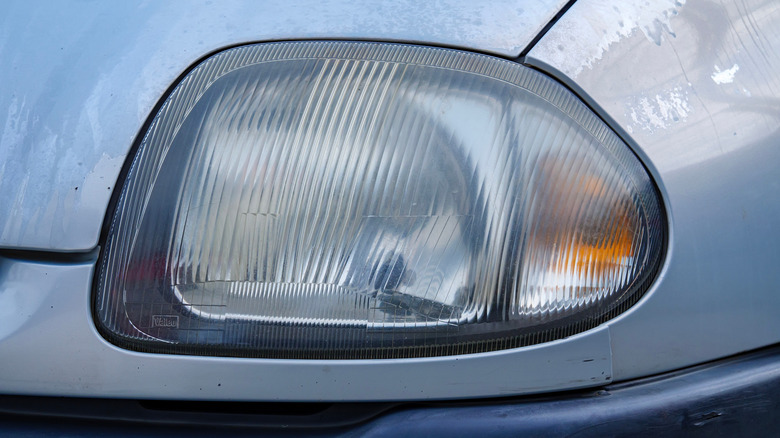 A dirty and hazy headlight of an old French car