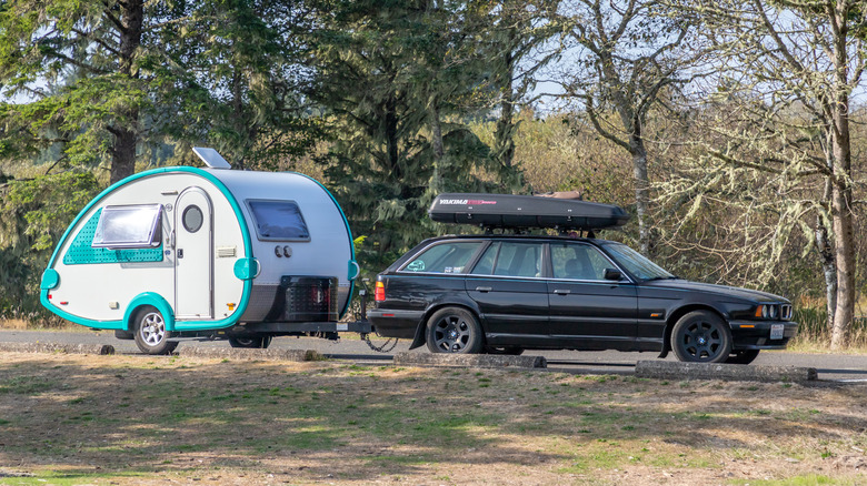 E34 BMW 5 Series Wagon towing a travel trailer.