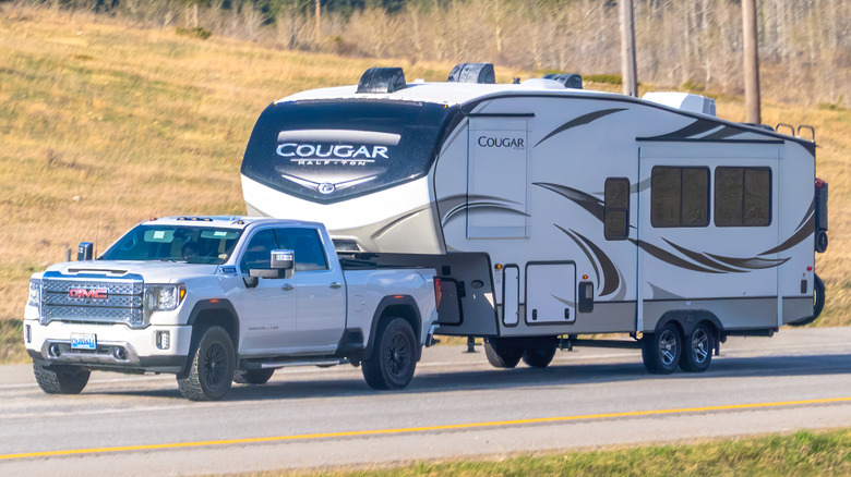 White GMC Sierra HD towing an RV.