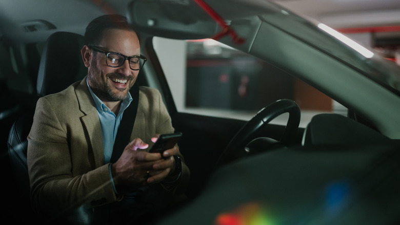Man playing with his phone in the car