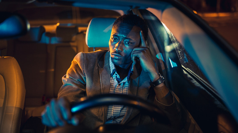 A man in his car looking stressed