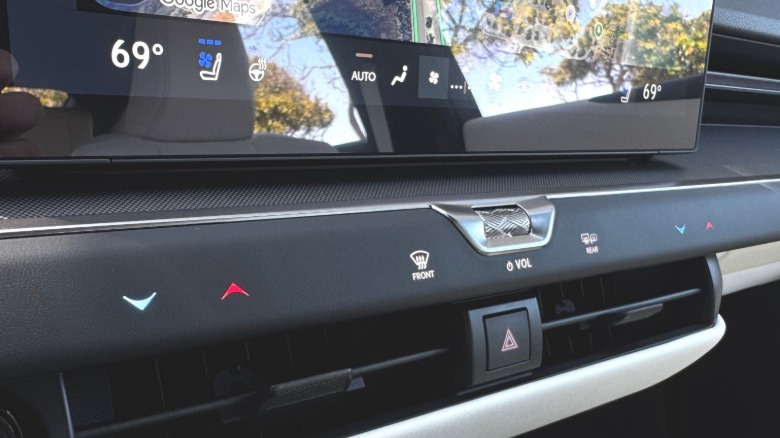 A close-up of the sparse dedicated row of HVAC controls and the volume roller