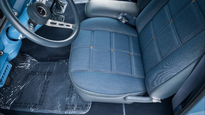 A close-up of the denim seats in the blue interior of the Cherokee with plastic on the floor mats