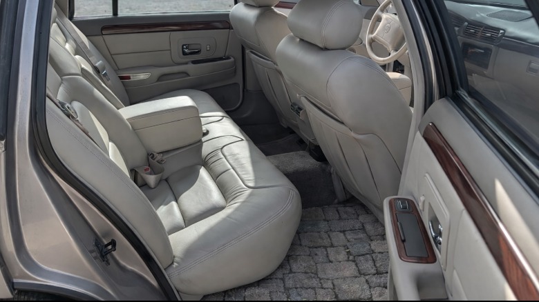 Back seat vew of a 1999 Cadillac DeVille with an AI-generated cobblestone floor