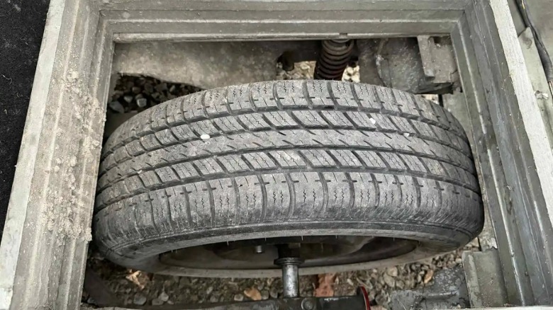 A photo looking at the rear wheel on the Civic three wheeler through the square hold in the floor.