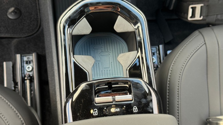 A close-up of the center armrest-mounted window controls in the EX30 with a single cupholder deployed in front of it