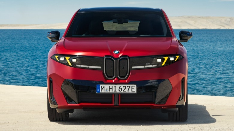 Front end of a satin red 2027 BMW iX4 M60