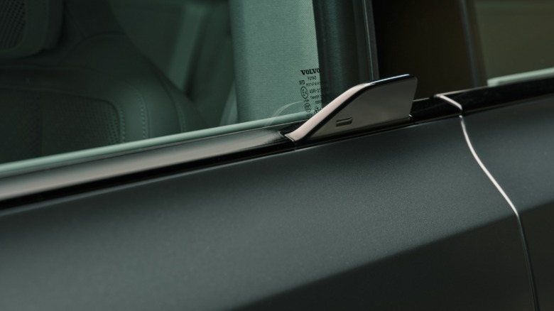 close-up shot of the door handle showing a little black fin under the window of a teal car