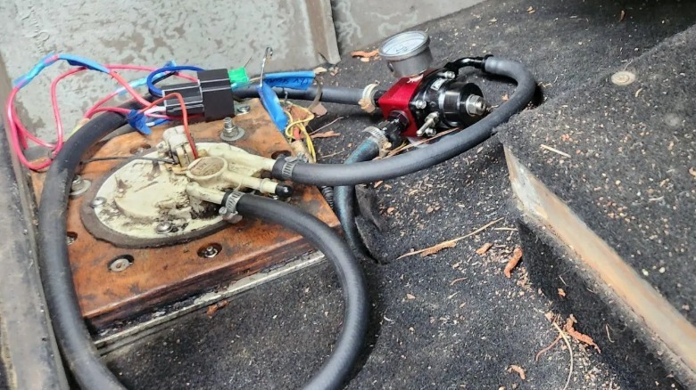 A close up photo of the Civic three wheeler's modified fuel pump and fuel pressure regulator with exposed wires