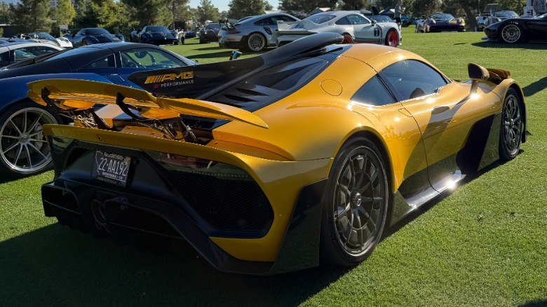 Rear 3/4 view of a yellow Mercedes-AMG One at a car show