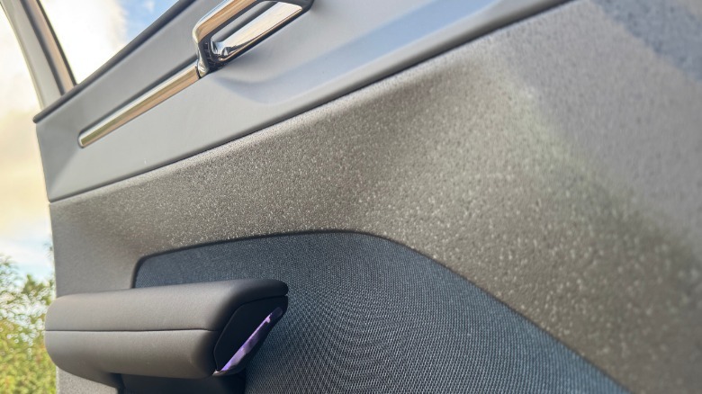 A close-up of the driver's door-mounted arm rest and the unique interior plastics on the EX30