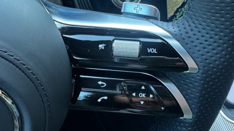 A close-up of the new steering wheel controls showing the physical volume roller and everything else still a touch pad