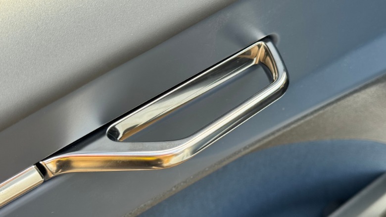 A close-up of the solid metal interior door pull on the driver's door