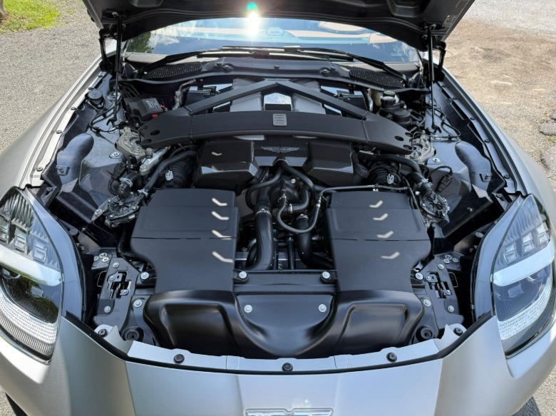 Engine bay of a silver Aston Martin Vanquish Volante