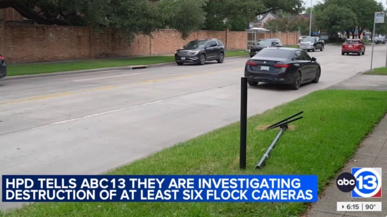 A Flock camera pole cut down on the side of the road