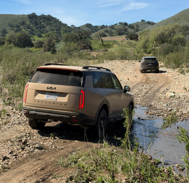 Rear end of a Kia Telluride driving through a creek