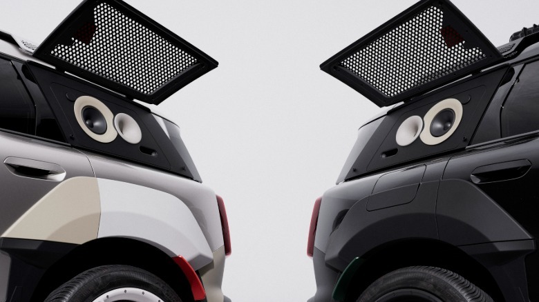 A close-up shot of the rear quarter windows of the two cars showing their speakers in front of a white backdrop