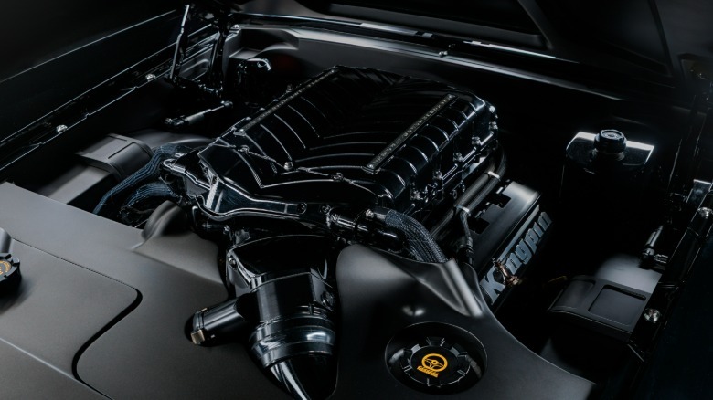 An under hood shot of Kingpin's engine with a gloss black supercharger cover