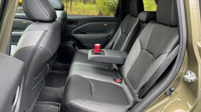 A look in the rear driver's side door showing the spacious black rear seats with the arm rest down