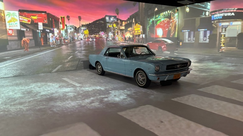 A photo of the first immersive experience and the powder blue Mustang driving down a projection of Sunset Blvd at dusk