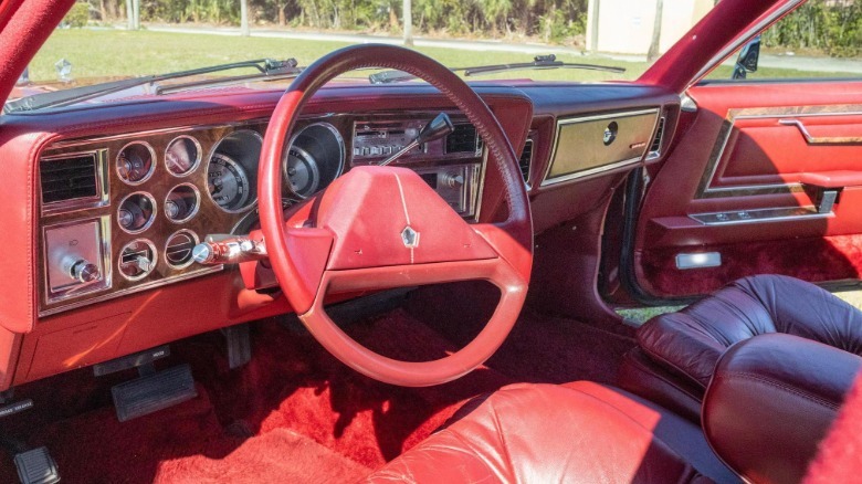 A photo looking at the red wood-and-chrome-covered dash of the Fifth Avenue