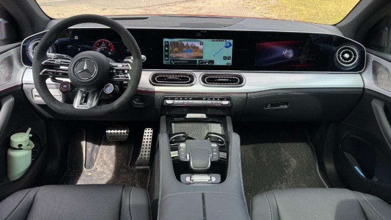 A wide shot of the dashboard in the GLE53 Coupe with a black leather interior showing the Superscreen with dirt visible out of the windshield