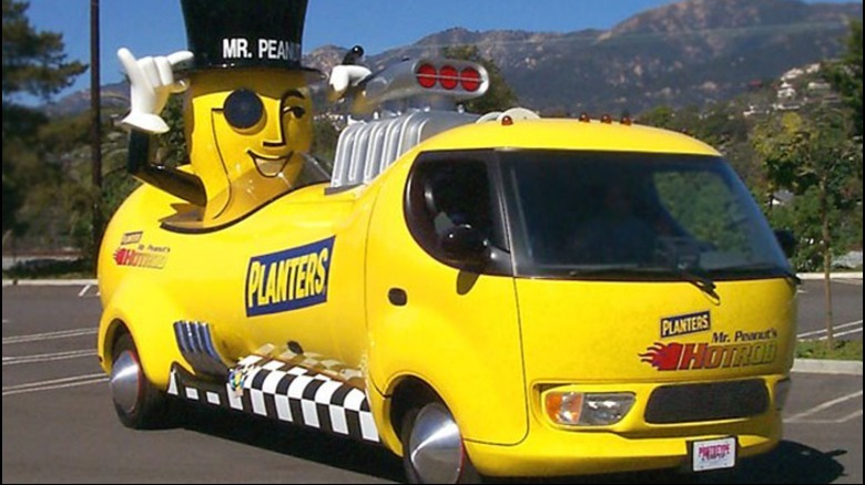 A front three-quarters shot of the 1999 NUTmobile Hot Rod parked in a lot in front of mountains