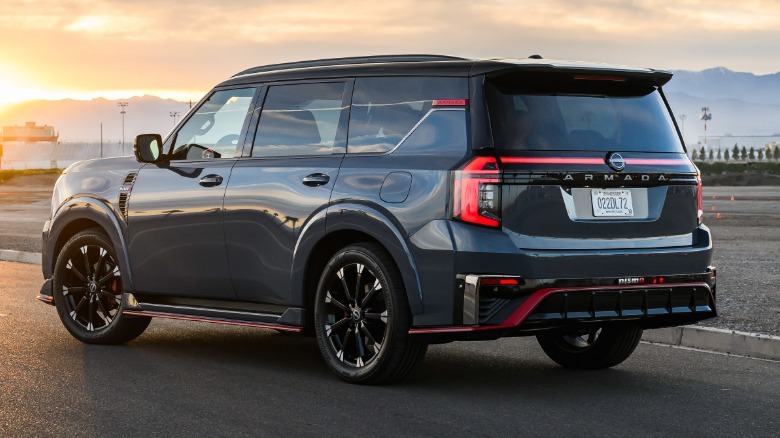 A rear three quarters shot of a gray Armada Nismo parked on tarmac in front of a sunset