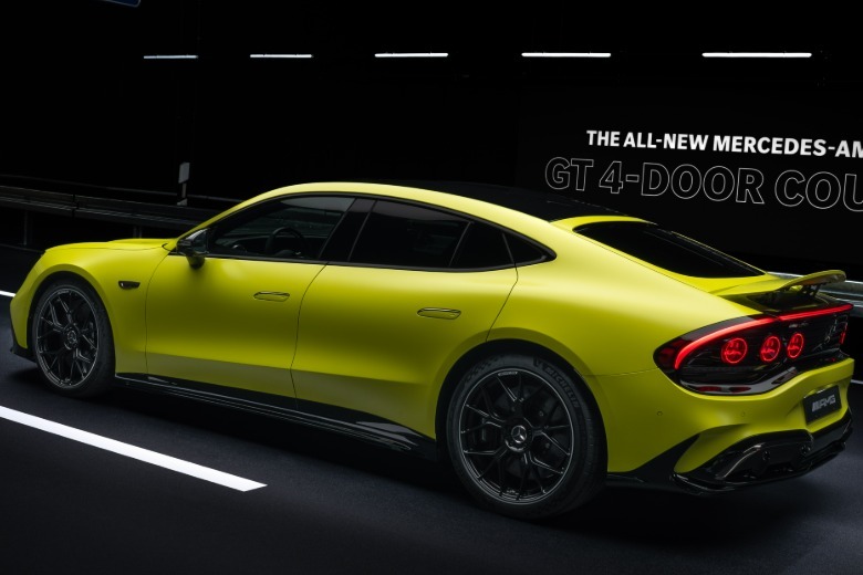 Rear 3/4 view of a yellow 2027 Mercedes-AMG GT 4-Door Coupe EV