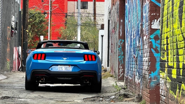 A rear shot of the bright blue Mustang EcoBoost parked in an alley surrounded by graffiti covered brick walls