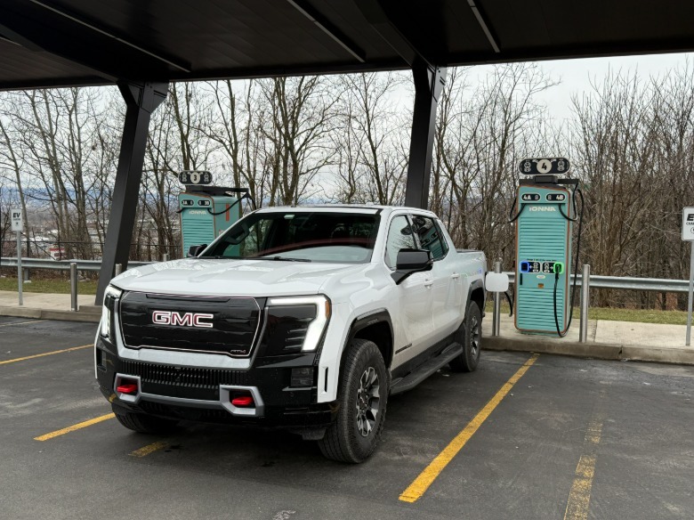 2026 GMC Sierra EV AT4 Max Range at a charging station