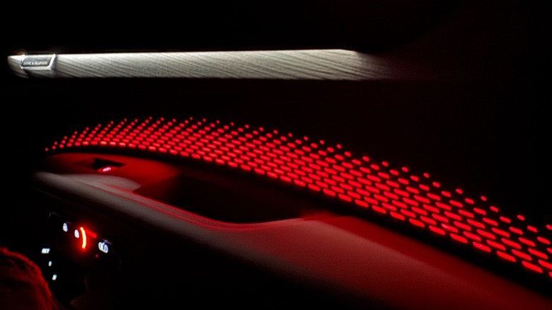 A detail shot of the passenger door-mounted arm rest and the patterned red ambient lights that come through the door card
