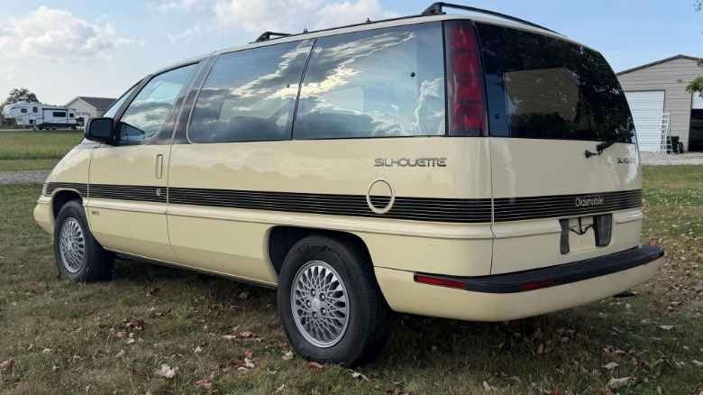 A rear three quarters shot of the yellow Silhouette parked on grass in front of homes