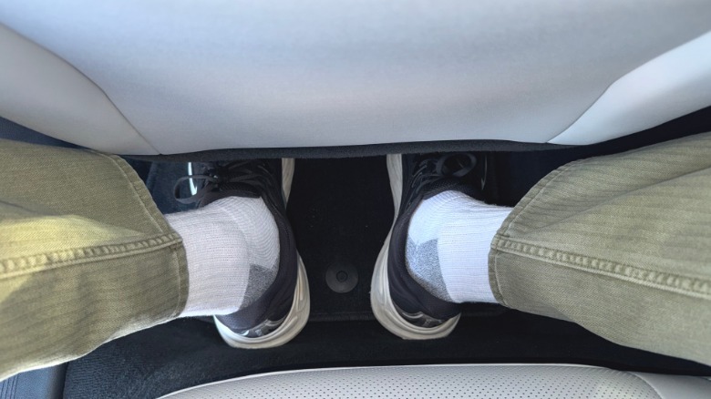A photo of my feet while sitting behind my preferred driving position showing my toes wedged under the seat and my heels backed up against the battery