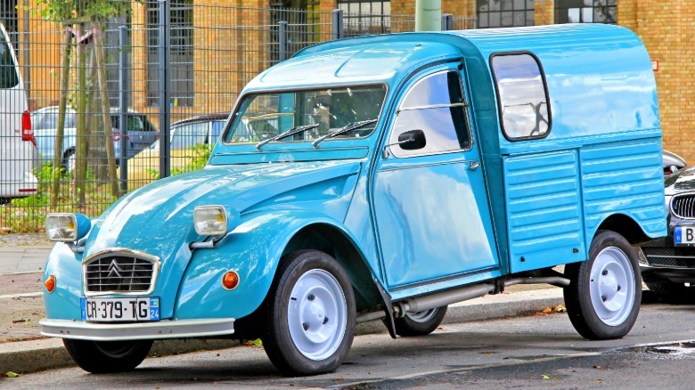 Front 3/4 view of an original Citroën 2 CV Fourgonnette parked on a city street
