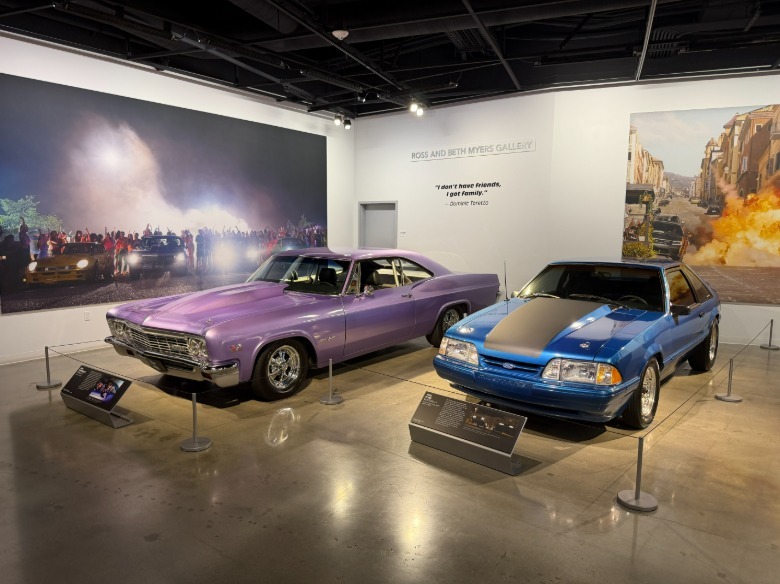 A lavender Chevrolet Impala and blue Ford Mustang at the Petersen