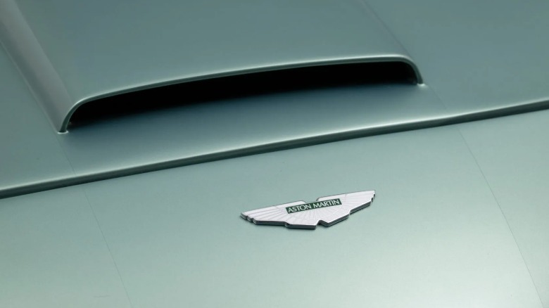 A closer look at the Aston badge on the nose of the light green Miata in front of the hood scoop