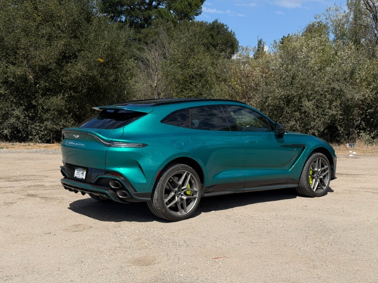 Rear 3/4 view of a green 2026 Aston Martin DBX S