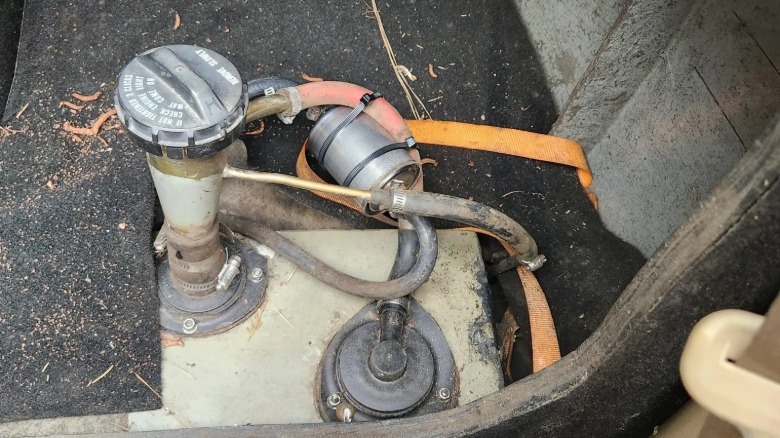 A close up photo of the Civic three wheeler's modified fuel tank and fuel filter that's tethered by zip ties