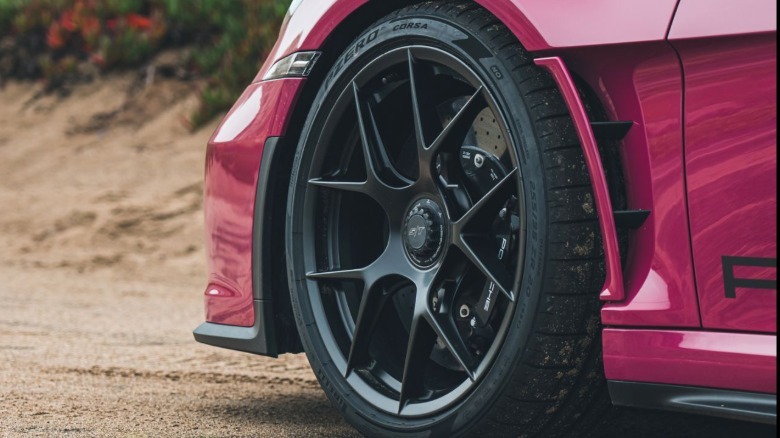close-up of the front wheel on a Ruby Star Neo 911 S/T parked on dirt