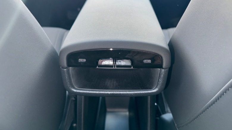 A close-up of the rear seat window controls mounted to the back of the center arm rest