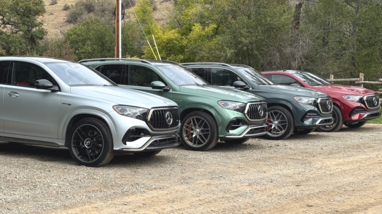 A photo of a silver GLE53 Coupe parked on gravel next to a green GLE53 SUV