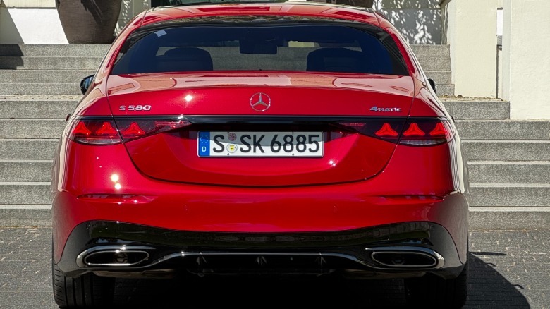 A rear shot of the red S580 parked in front of concrete stairs and a white building