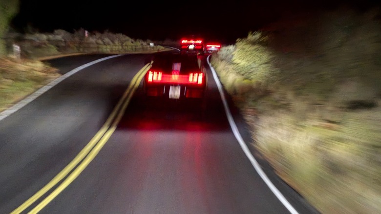blurry photo out the windshield of a Q9 with its matrix beam headlights showing a dark spot surrounding the lead cars but the rest of the view illuminated