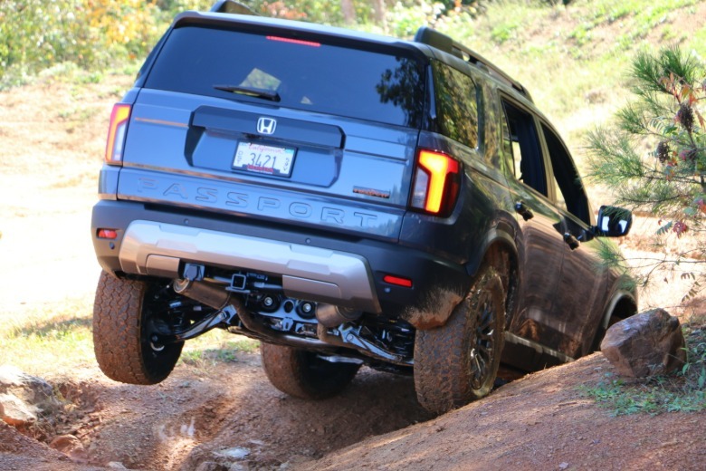 2027 Honda Passport TrailSport rear 3/4 view off-roading at OEX in North Carolina