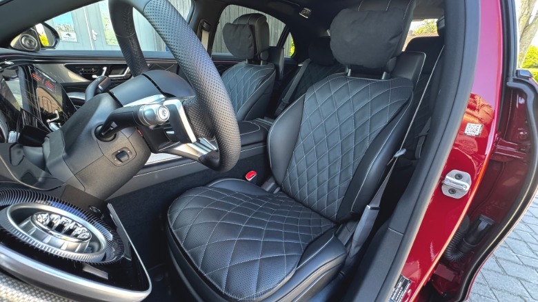 A look in the open driver's door at the black leather front seats in the red S580