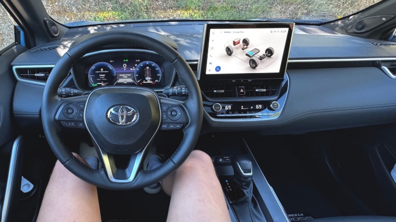 A photo from my POV showing the black dashboard in the Corolla Cross Hybrid with the energy flow display up on the center screen