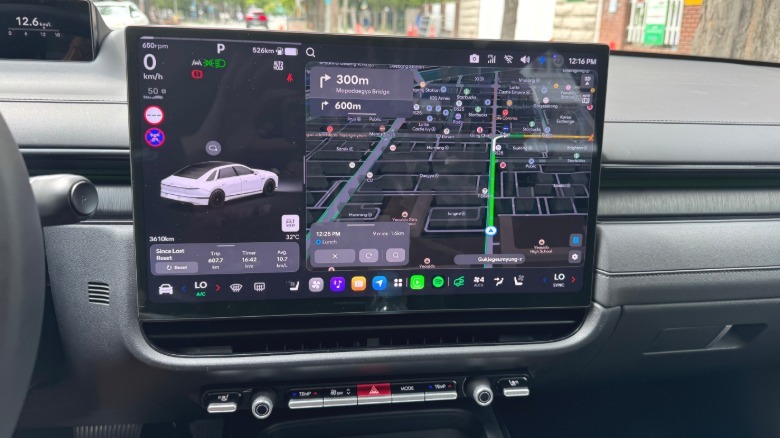 A photo of the Pleos Connect infotainment screen and the row of buttons below it